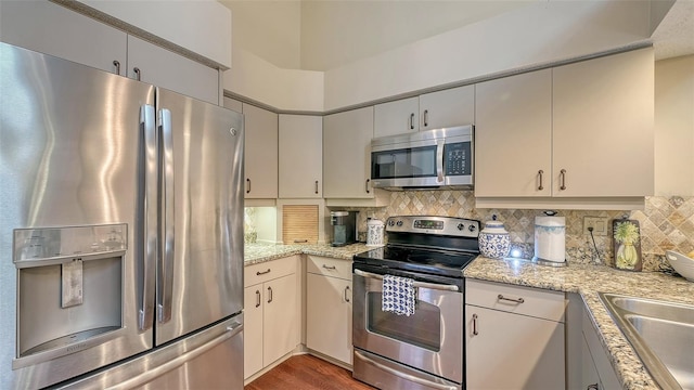 4691 Las Brisas Ln, Sarasota, FL 34238 - kitchen with wood finished floors, a sink, backsplash, and stainless steel appliances