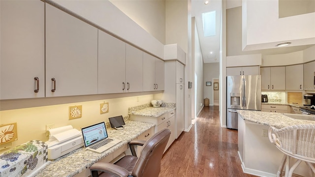 4691 Las Brisas Ln, Sarasota, FL 34238 - kitchen with a high ceiling, wood finished floors, stainless steel fridge with ice dispenser, and a kitchen bar