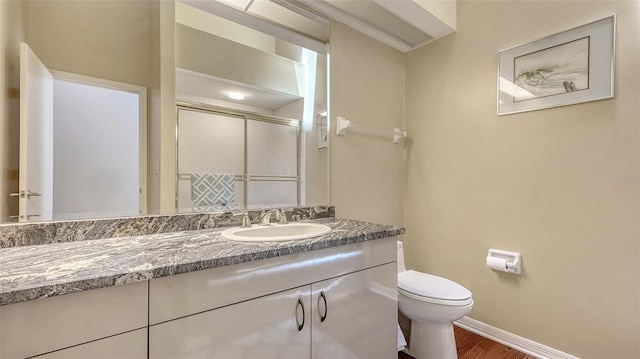4691 Las Brisas Ln, Sarasota, FL 34238 - full bathroom featuring a stall shower, wood finished floors, vanity, baseboards, and toilet