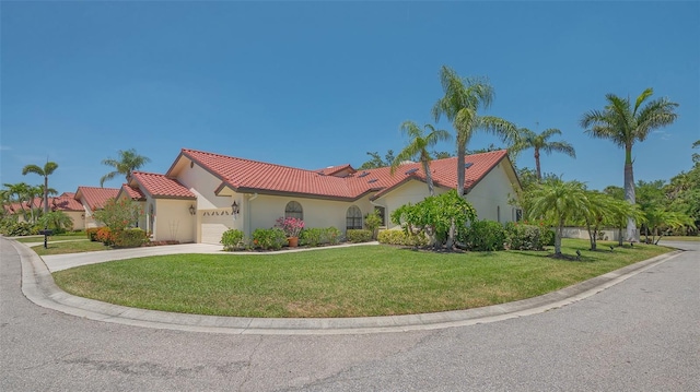 4691 Las Brisas Ln, Sarasota, FL 34238 - mediterranean / spanish house featuring an attached garage, a tile roof, stucco siding, a front yard, and driveway