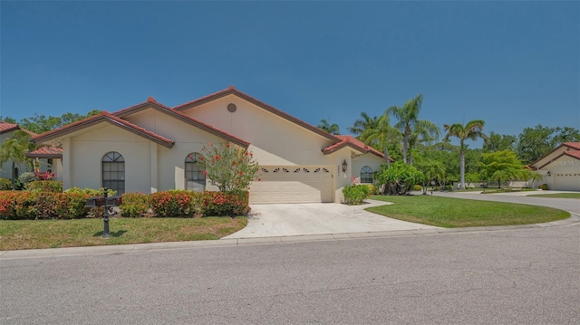 4691 Las Brisas Ln, Sarasota, FL 34238 - mediterranean / spanish house with a garage, stucco siding, driveway, and a front yard