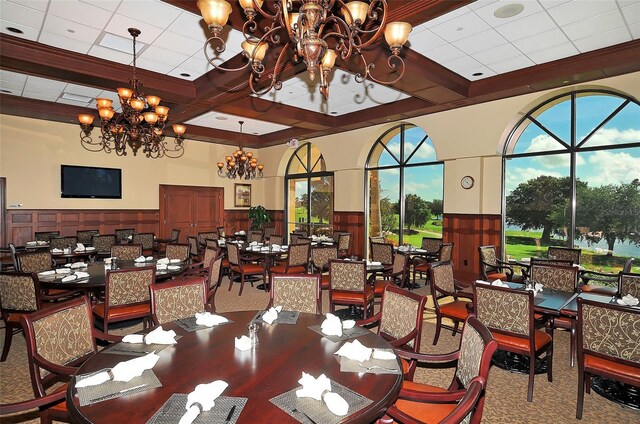 4691 Las Brisas Ln, Sarasota, FL 34238 - dining space featuring carpet, coffered ceiling, a notable chandelier, and beamed ceiling