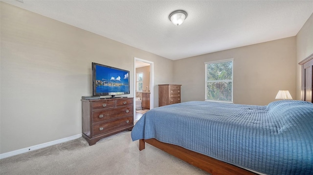 5403 Mang Pl, Sarasota, FL 34238 - bedroom with baseboards, light carpet, and ensuite bathroom