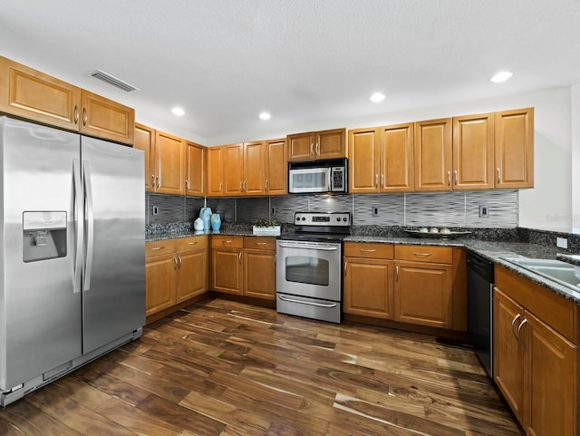 1771 Ringling Blvd Unit 1104, Sarasota, FL 34236 - kitchen featuring appliances with stainless steel finishes, tasteful backsplash, visible vents, and dark wood-type flooring