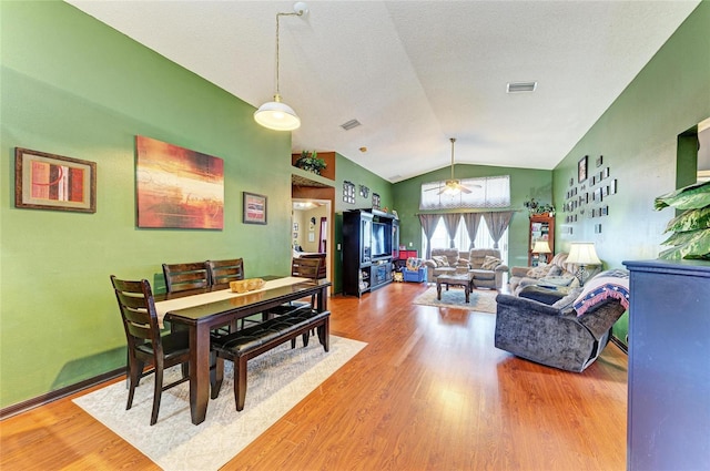 dining room with ceiling fan, vaulted ceiling, and wood finished floors