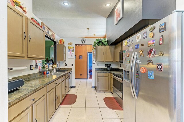 kitchen with appliances with stainless steel finishes, a sink, light tile patterned floors, a textured ceiling, and recessed lighting