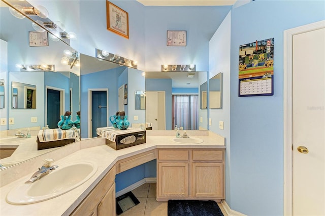 bathroom featuring tile patterned flooring, double vanity, and baseboards