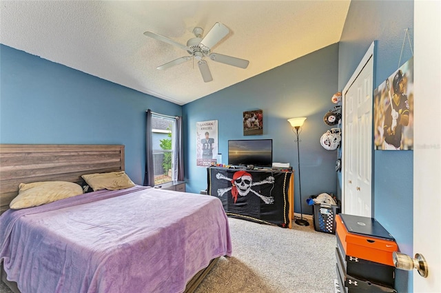 bedroom with lofted ceiling, carpet flooring, a ceiling fan, and a textured ceiling