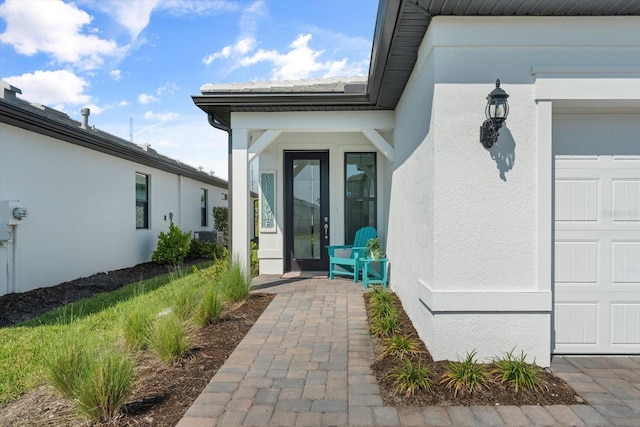 entrance to property with stucco siding and central AC unit