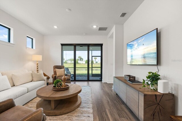 living room featuring dark wood-style floors, recessed lighting, and baseboards