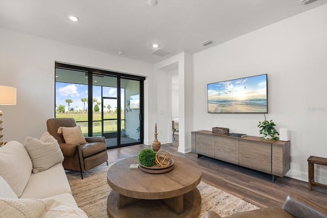 living room featuring wood finished floors, baseboards, and recessed lighting