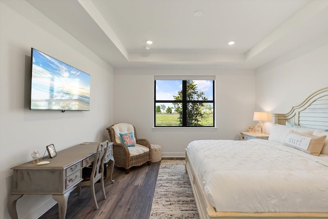 bedroom featuring wood finished floors, a tray ceiling, recessed lighting, and baseboards