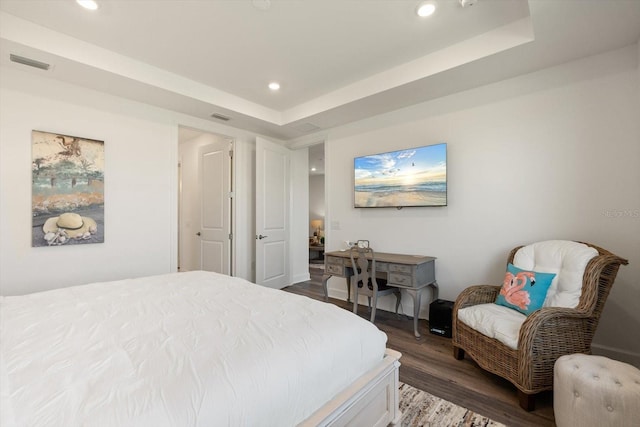 bedroom featuring dark wood-style floors, recessed lighting, and a raised ceiling