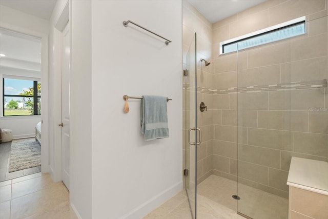 full bath with a stall shower, plenty of natural light, tile patterned floors, and baseboards