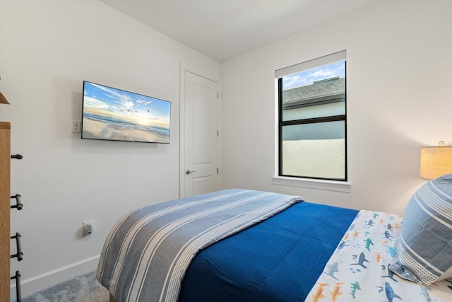 bedroom with baseboards and carpet