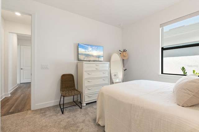 bedroom featuring baseboards and light colored carpet