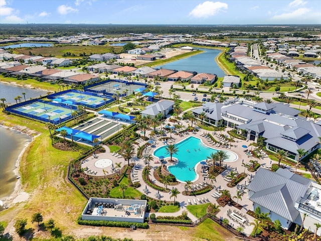 aerial view of residential area featuring a pool and a large body of water