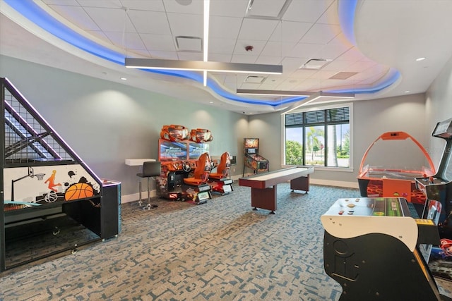 rec room with a raised ceiling, carpet, and baseboards