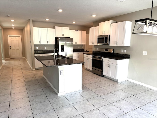kitchen featuring a sink, stainless steel appliances, baseboards, white cabinetry, and light tile patterned floors