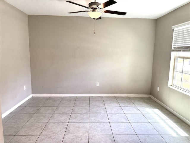 unfurnished room featuring a ceiling fan, baseboards, and light tile patterned flooring