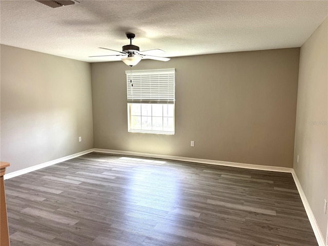 spare room featuring a ceiling fan, a textured ceiling, baseboards, and dark wood-type flooring
