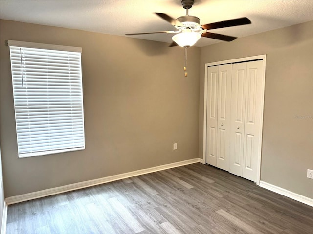 unfurnished bedroom featuring baseboards, a closet, and wood finished floors
