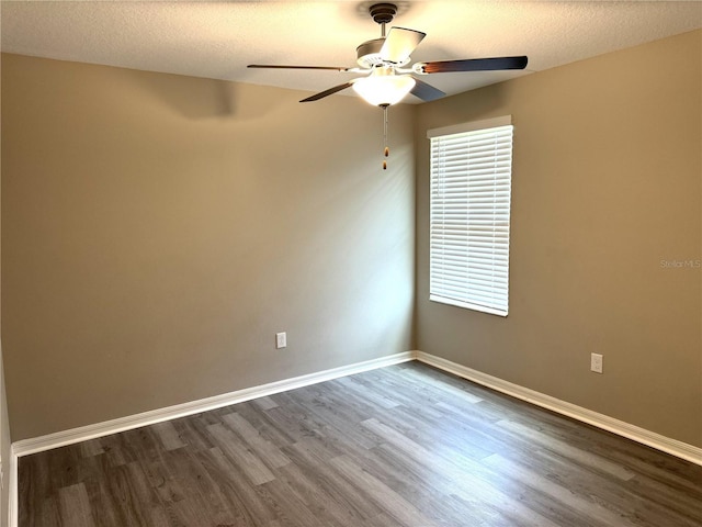 empty room featuring a textured ceiling, baseboards, a ceiling fan, and wood finished floors