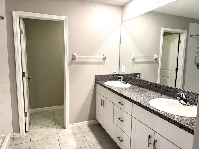 full bathroom featuring double vanity, tile patterned floors, walk in shower, and a sink