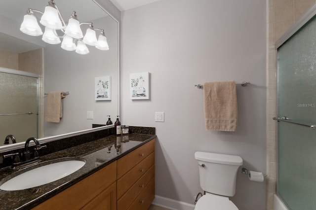 8045 Tybee Ct Unit 8045, University Park, FL 34201 - bathroom featuring a notable chandelier, vanity, toilet, baseboards, and a shower with door