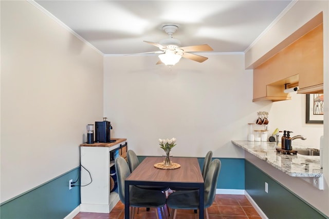 dining room with a ceiling fan, baseboards, and ornamental molding