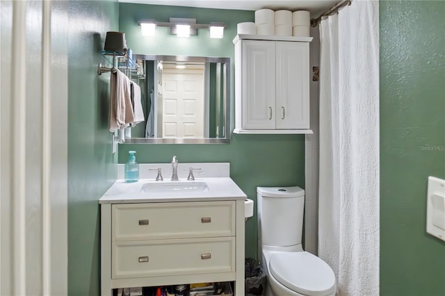 bathroom featuring toilet, vanity, and a shower with shower curtain