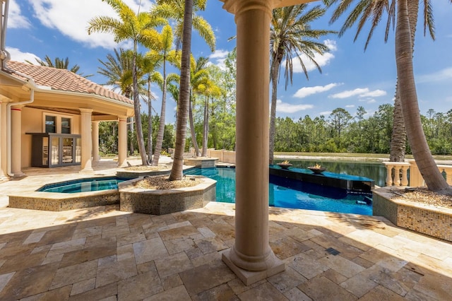 outdoor pool featuring a patio and an in ground hot tub