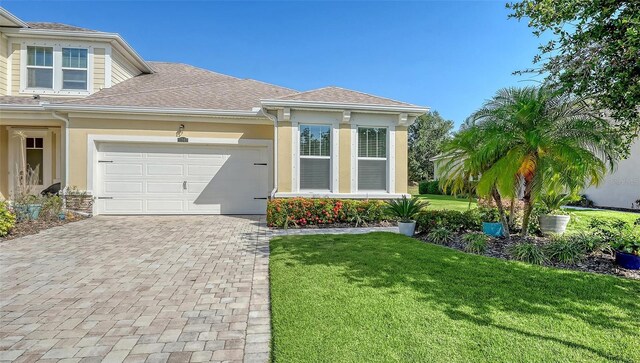 11847 Meadowgate Pl, Lakewood Ranch, FL 34211 - view of front of property with a front lawn, a garage, decorative driveway, roof with shingles, and stucco siding