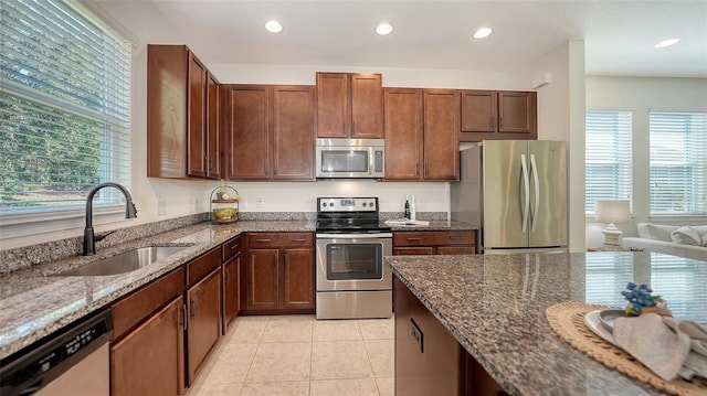 11847 Meadowgate Pl, Lakewood Ranch, FL 34211 - kitchen featuring dark stone countertops, light tile patterned floors, a sink, appliances with stainless steel finishes, and recessed lighting