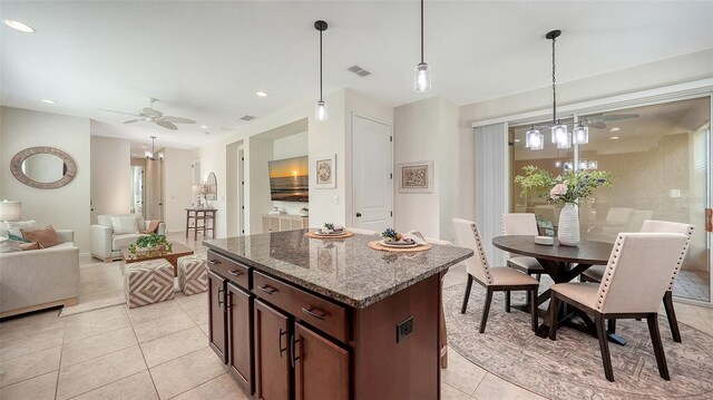 11847 Meadowgate Pl, Lakewood Ranch, FL 34211 - kitchen with light tile patterned floors, visible vents, a kitchen island, decorative light fixtures, and ceiling fan with notable chandelier