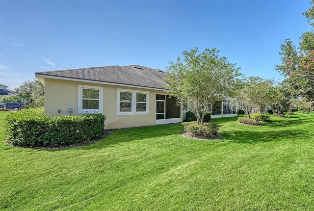 11847 Meadowgate Pl, Lakewood Ranch, FL 34211 - rear view of house with stucco siding, a yard, and a shingled roof