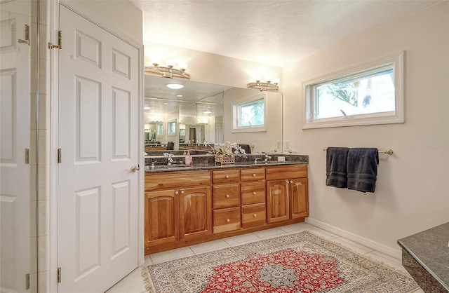 621 Ivanhoe Ln, Holmes Beach, FL 34217 - bathroom with a shower with shower door, double vanity, tile patterned floors, and a sink