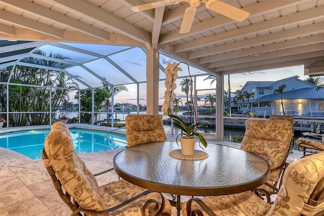 621 Ivanhoe Ln, Holmes Beach, FL 34217 - pool at dusk featuring a patio area, an outdoor pool, a ceiling fan, a water view, and a lanai