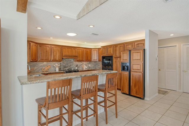 621 Ivanhoe Ln, Holmes Beach, FL 34217 - kitchen featuring paneled fridge with ice dispenser, light tile patterned floors, a sink, black microwave, and a peninsula