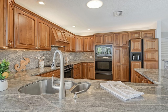 621 Ivanhoe Ln, Holmes Beach, FL 34217 - kitchen with oven, a sink, visible vents, light stone countertops, and brown cabinetry