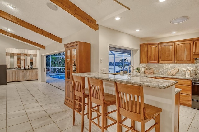 621 Ivanhoe Ln, Holmes Beach, FL 34217 - kitchen featuring decorative backsplash, lofted ceiling with beams, light tile patterned flooring, light stone countertops, and recessed lighting