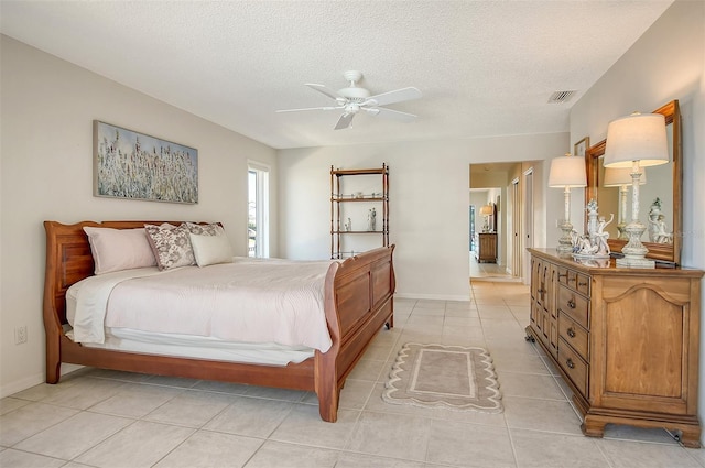 621 Ivanhoe Ln, Holmes Beach, FL 34217 - bedroom with visible vents, light tile patterned flooring, baseboards, a textured ceiling, and ceiling fan