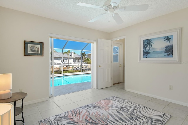 621 Ivanhoe Ln, Holmes Beach, FL 34217 - interior space with a textured ceiling, baseboards, access to outside, and light tile patterned floors