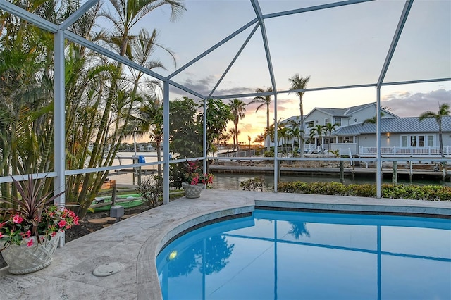 621 Ivanhoe Ln, Holmes Beach, FL 34217 - pool at dusk with a lanai, an outdoor pool, and a water view