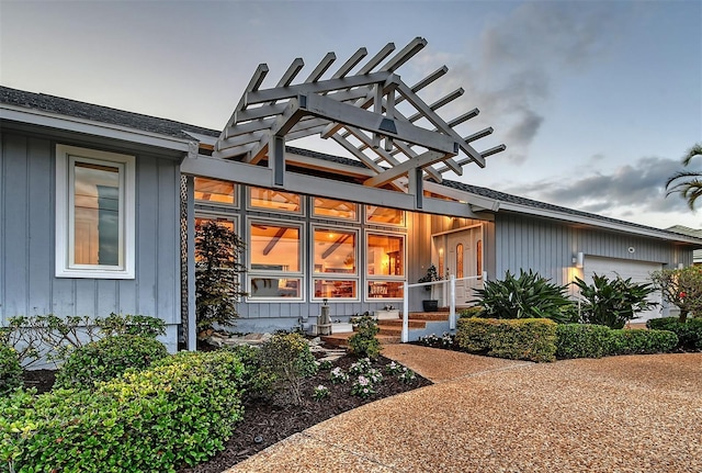 621 Ivanhoe Ln, Holmes Beach, FL 34217 - entrance to property with board and batten siding, an attached garage, and roof with shingles