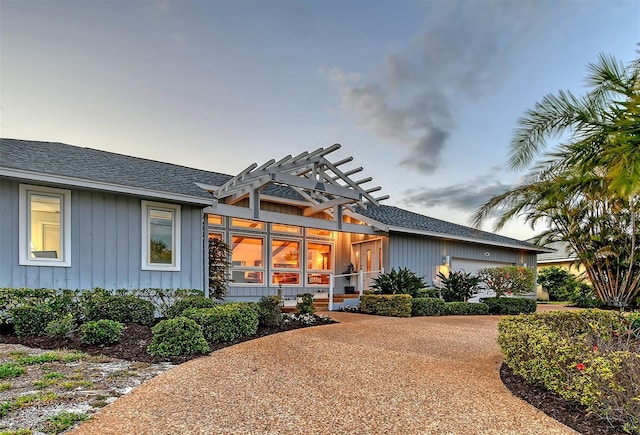 621 Ivanhoe Ln, Holmes Beach, FL 34217 - rear view of property with an attached garage, roof with shingles, board and batten siding, and concrete driveway