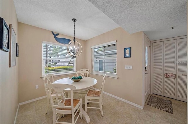 dining room with an inviting chandelier, a textured ceiling, and a wealth of natural light