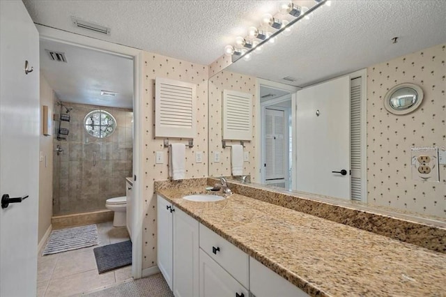 full bathroom with tiled shower, toilet, a textured ceiling, and visible vents