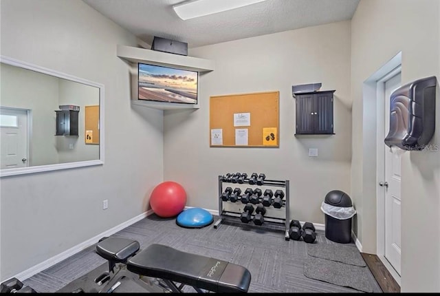 exercise area featuring carpet floors and baseboards