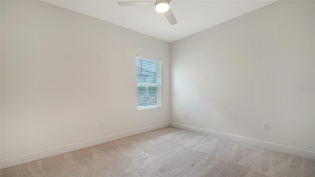 carpeted empty room featuring a ceiling fan and baseboards